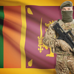 Soldier with machine gun and flag on background - Sri Lanka
