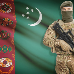 Fototapeta premium Soldier with machine gun and flag on background - Turkmenistan