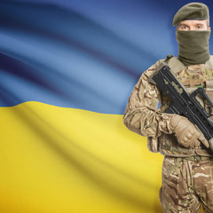 Fototapeta premium Soldier with machine gun and flag on background - Ukraine