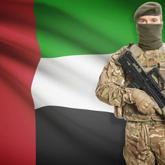 Fototapeta premium Soldier with machine gun and flag on background - United Arab Emirates