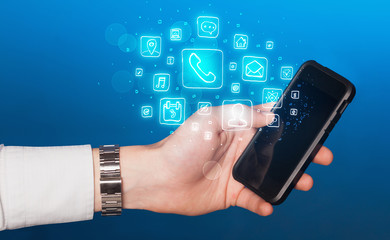 Hand holding smartphone with mobile app icons
