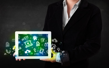 Person holding tablet with green media icons and symbols