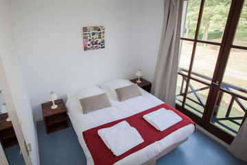 Double Bed In The Bedroom With Desk Lamp Near It