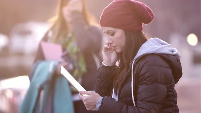 Up close view of woman using tablet as she sits near the road in.