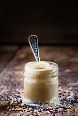 Freshly prepared mustard sauce in a small glass jar with a spoon