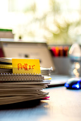 By Monday; Stack of Documents and Laptop at working Desk.