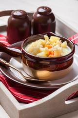 Homemade cauliflower soup in a brown bowl.