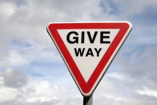 Give Way Sign against blue sky background