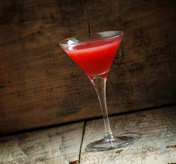 Red margarita cocktail in glass on old wooden background, dark t