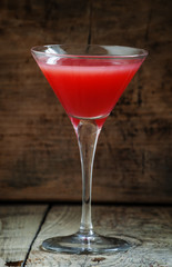 Red margarita cocktail in glass on old wooden background, dark t