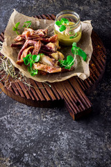 Smoked pork ears with mustard sauce on chopping board.