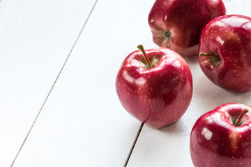 ripe red apples on white wooden table