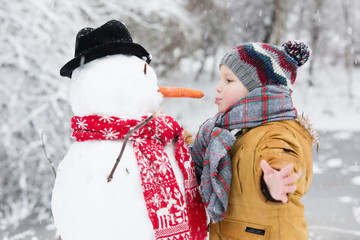 boy playing with a snowman