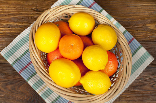 fruits: lemons and oranges on a wooden table