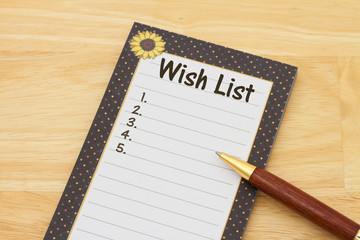 A notepad and pen on a desk with text Wish List and copy-space