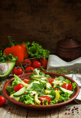 Salad with avocado, cherry tomatoes, peppers, cucumbers, herbs,