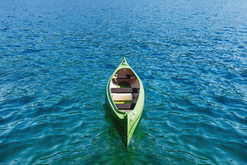 Canoe floating on the transparent sea water.
