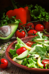 Salad with avocado, cherry tomatoes, peppers, cucumbers, herbs,