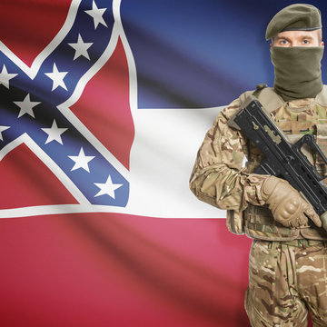Soldier with machine gun and USA state flag on background - Mississippi