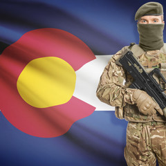 Fototapeta premium Soldier with machine gun and USA state flag on background - Colorado