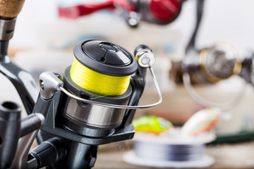 fishing rod with reel on background of tackles in boxes