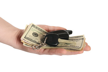 Dollars in a hand and car keys isolated