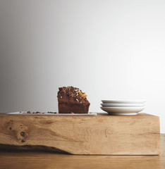 Piece of cake and tea dishes on wooden brick