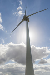 Modern windmill with against light from the Sun.