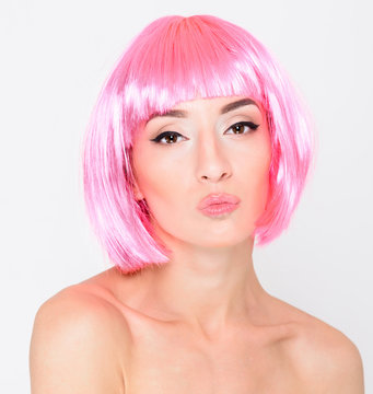 Head shot of sexy young woman in pink wig on white background