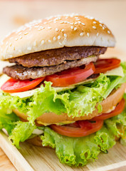 Delicious hamburger and french fries on wooden table