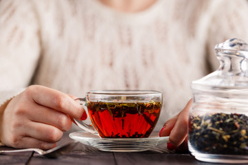 Female hands holding cup with hot herbal tea