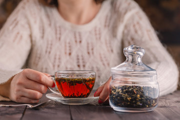 Female hands holding cup with hot herbal tea