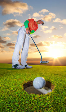 Man playing golf against colorful sunset