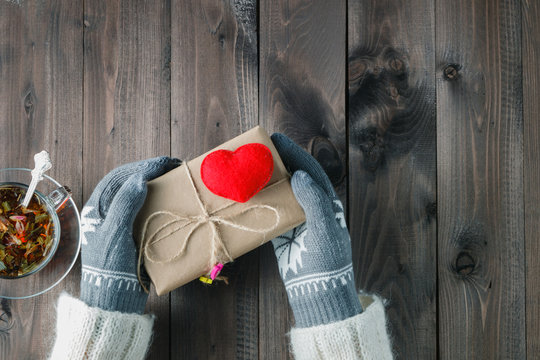 Female hands in glove give love present