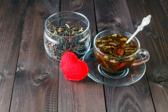 Hot herbal tea on dark aged wooden background