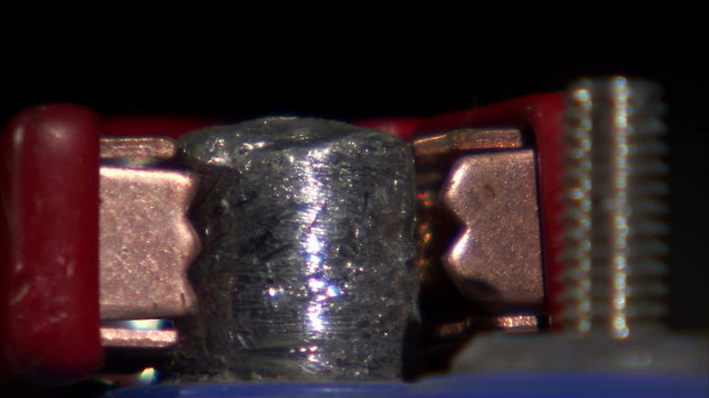 Close up of a charger clamp placed on a battery clamp.
