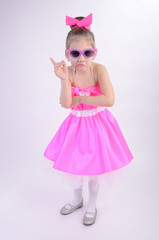 grimacing girl with glasses in a bright dress