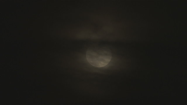 Shot of a full moon with clouds covering the top half