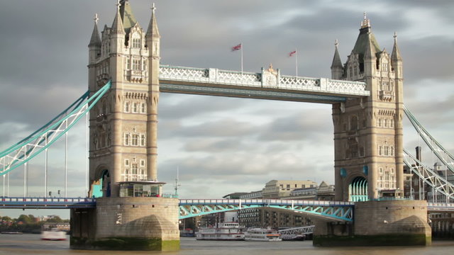 Time lapse of the Tower Bridge bascules raising, boats pass under, located in London, England.