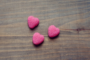 Valentine's Day candy hearts on a wooden background
