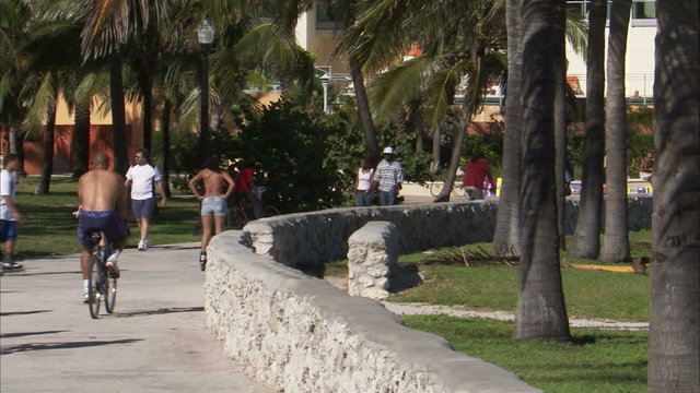 People walking, biking, rollerblading on a path in Miami.