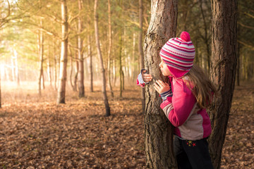 Girl hiding behind a tree