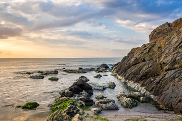 Fototapeta na wymiar rocks and seaweed on rocky coast of the sea