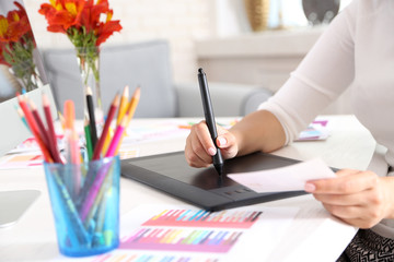 Artist drawing on graphic tablet in office