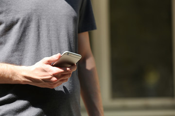 Man holding smart mobile phone outdoors
