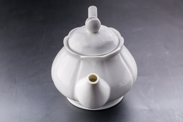 teapot and tea cup over dark background