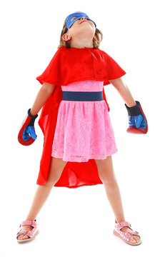 Superhero little girl poses in boxing gloves isolated on white background