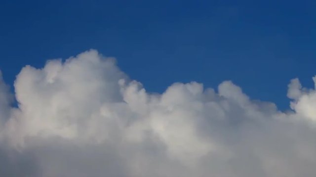 Heaven river of lumpy puffy sunny clouds on deep blue sky background. Meditative view of calm and relaxing motion of white steam stream. Upper edge of sunlit cloud sea.
