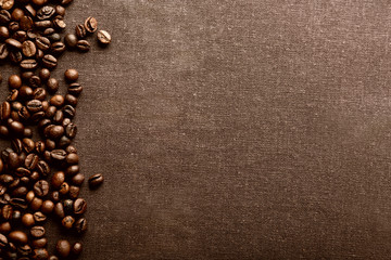 Roasted coffee beans on grey textile background