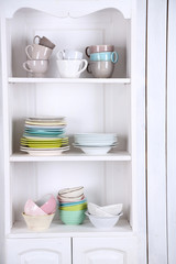 Fototapeta na wymiar Different clean dishes on wooden shelves